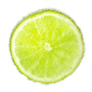 Nice ripe and juicy slice of a lime covered with bubbles. Isolated on white.