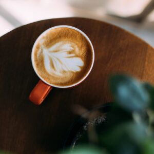 A latte with orange mug on wooden table