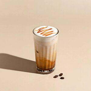 Iced Caramel Macchiato – Espresso layered over cold milk with a sweet caramel drizzle, served in a glass on a beige background with warm lighting.