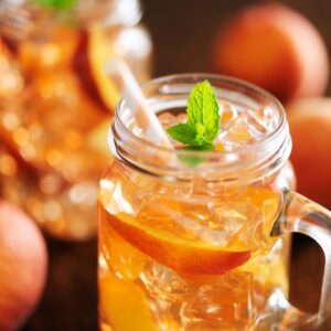 jar of peach tea with striped straw close up